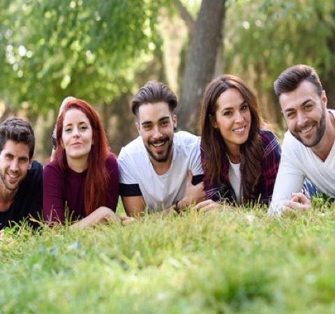 Five friends lying on the grass, photographed remotely